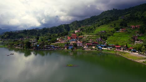 Stunning-aerial-view-of-a-village-on-Phewa-lakeside-at-the-foothills-of-the-Annapurna-mountain-in-Pokhara,-Nepal