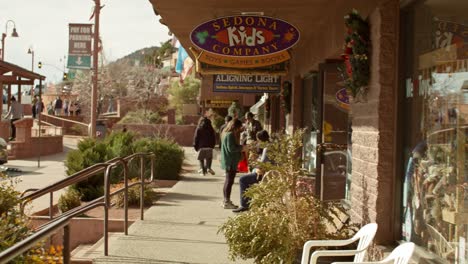 Downton-Sedona,-Arizona-with-shoppers-walking-on-sidewalk-with-shot-panning-right-to-left