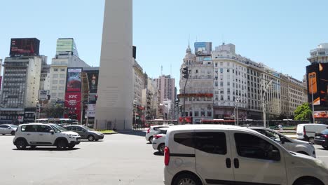 Cars-Traffic-Drive-Through-9-de-Julio-Avenue-and-Obelisk-of-Downtown-City-Center-Business-and-National-Landmark