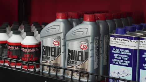 Shelf-with-bottles-of-automotive-oils-of-the-American-brand-Phillips-66-and-brake-fluid,-inside-a-distributor-store