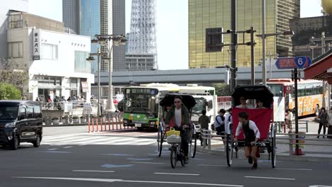 Rickshaw-Driver-Pulling-Tourists-Across-Crosswalk-In-Asakusa