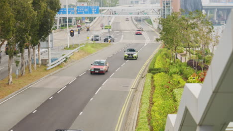 Trucks-and-compact-cars-zoom-across-multi-lane-highway-exit-traveling-in-Asia