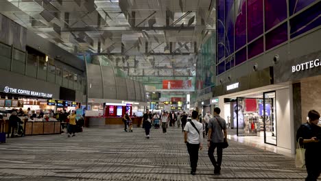 Dentro-Del-Aeropuerto-De-Singapur-Como-Un-Centro-Comercial-Y-Pasarelas-Por-Las-Que-Caminan-Los-Turistas-Y-La-Población-Local