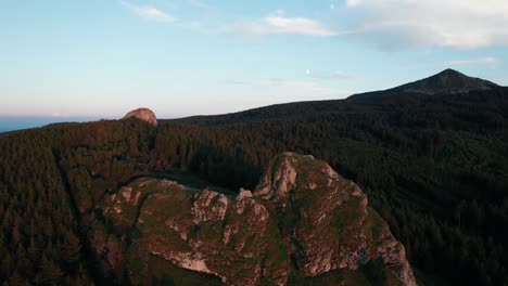 drone-shot-around-the-"dent-du-diable"-with-the-mont-mezenc-in-the-background-at-sunset-in-haute-loire-departement,-region-auvergne-rhone-alpes,-france