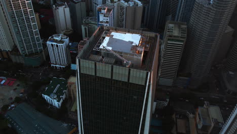 Construction-site-on-top-of-a-skyscrapers-in-Makati-city,-Manila---Aerial-view