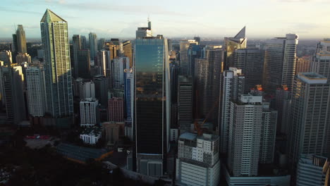 Aerial-view-around-skyscrapers-of-Makati-city,-golden-hour-in-Manila,-Philippines