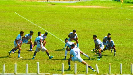 Calentamiento-Del-Equipo-De-Fútbol-Junior-Estirándose-En-Un-Vibrante-Y-Soleado-Campo-Verde-En-Bangladesh