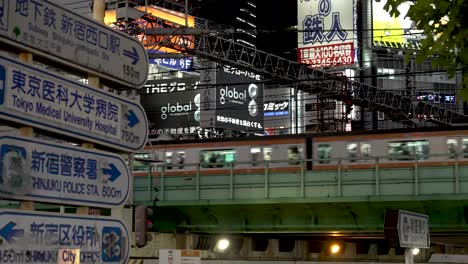 Shinjuku-Viertel-Mit-Seiner-Fülle-An-Bildern,-Werbung,-Schildern,-Autos,-Zügen-Und-Menschen