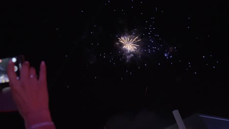 Frau-Macht-Ein-Video-Vom-Feuerwerk,-Das-Während-Einer-Gesellschaftlichen-Veranstaltung-Am-Himmel-Explodiert