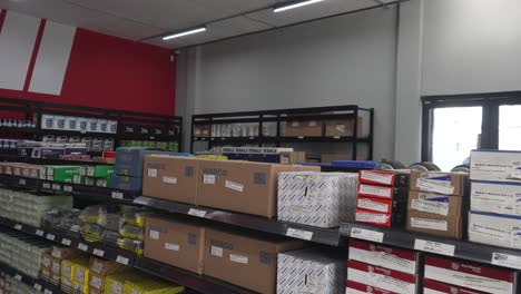 Rack-inside-truck-and-car-parts-distributor-store,-displaying-several-boxes-with-different-brands-of-supplies-and-accessories