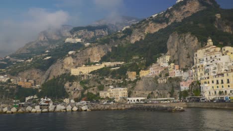 Panorama-Der-Stadt-Vom-Strandpier-|-Amalfiküste-Italien-Reisetourismus-Sonnenaufgang-Klippenküste,-Europa,-Gehen,-Wackelig,-4k