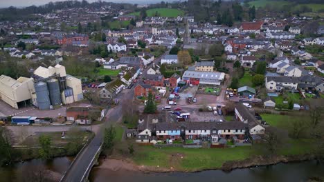 Forward-aerial-drone-flight-towards-St-Mary's-Church-in-the-rural-village-of-Uffculme-in-Mid-Devon-in-the-West-of-England-incorporating-the-River-Culm
