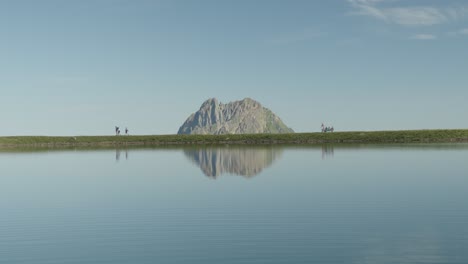 Ein-Klarer-See,-Eine-Majestätische-Bergkulisse-Und-Wanderer-Am-Ufer