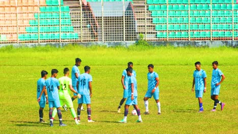Práctica-De-Calentamiento-Del-Equipo-De-Fútbol-Juvenil-En-Un-Vibrante-Campo-Verde-Y-Soleado-En-Bangladesh