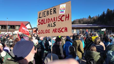 people-protesting-peacefully-against-the-far-right-holding-up-a-sign-whicht-translates-to-"Better-to-be-in-solidarity-than-solid-Aryan