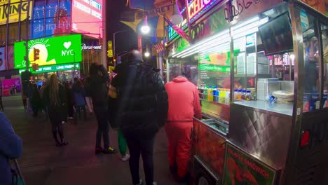 Halal-street-food-vendor-in-Time-Square,-New-York-City-surrounded-by-tourists