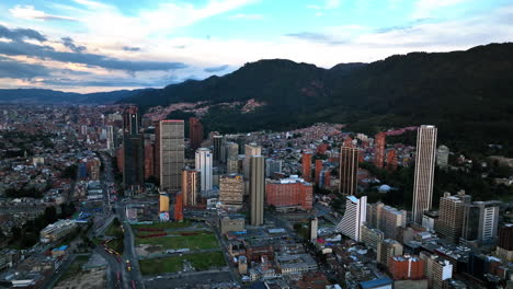 Disparo-Panorámico-Con-Drones-Rodeando-Un-Edificio-Alto-En-El-Centro-De-Bogotá,-Puesta-De-Sol-En-Colombia