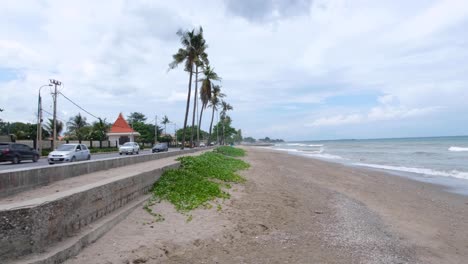 Malerische-Landschaftsansicht-Des-Sandigen-Strandes-Von-Pantai-Kelapa-Mit-Kokospalmen-Auf-Der-Tropischen-Inselhauptstadt-Osttimor,-Südostasien