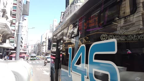POV-Buswagen-Und-Taxis-Fahren-Am-Sommermorgen-Durch-Die-Berühmte-Innenstadtstraße-Corrientes-Avenue-In-Der-Pulsierenden-Südamerikanischen-Hauptstadt