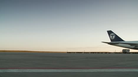Cargo-planes-on-tarmac-during-sunrise-with-clear-skies-and-airport-vehicles-in-background