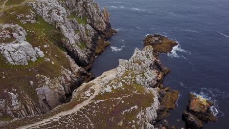 Flying-above-a-piece-of-land-with-a-rocky-cliffside-by-the-sea