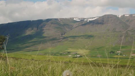 Timelapse-De-Campos-Y-Hermosos-Picos-Nevados-En-El-Norte-De-Islandia-Mientras-Las-Sombras-De-Los-Clounds-Cruzan-Las-Montañas