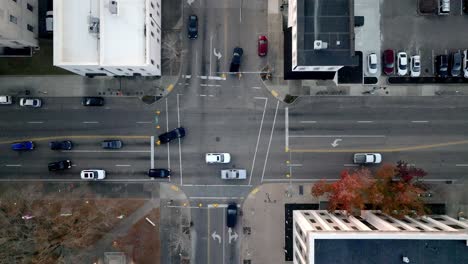 Downtown-Jackson,-Tennessee-traffic-intersection-with-vehicles-moving-and-stable-drone-video