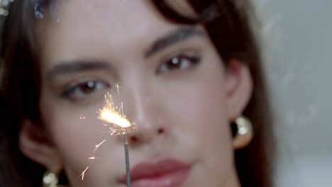 The-lighting-of-a-firework-sparkler,-in-the-background-a-female-model-dreams-away