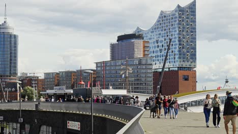 Elbphilharmonie-Concert-Hall,-Tourists-Walking-Around,-Summer,-Hamburg,-Germany,-Static-Wide-Establishing