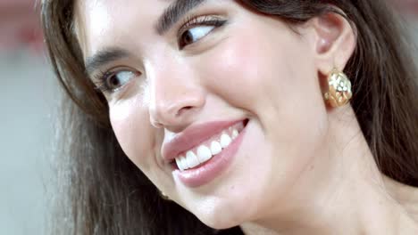 Facial-close-up-shot-of-a-smiling-fashion-model-wearing-gold-earrings