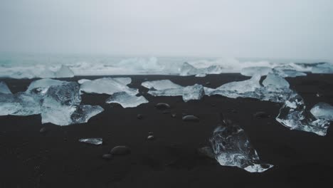Small-jagged-ice-chunks-on-Diamond-beach-in-Iceland-as-waves-crash