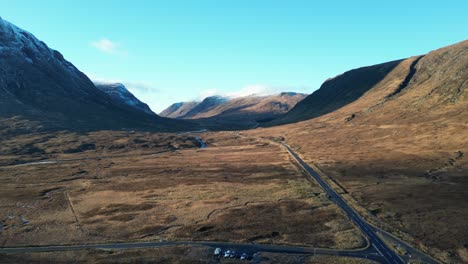 Glencoe-valley-with-road-winding-through,-serene-Scottish-Highlands,-daylight,-aerial-view