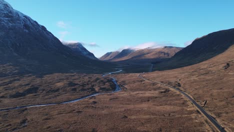 Glencoe-Valley-with-winding-road-and-river,-Scottish-Highlands,-serene-landscape,-aerial-view