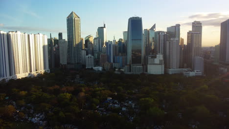 Drone-shot-over-the-Manila-South-Cemetery-toward-skyscrapers-of-Makati,-Philippines