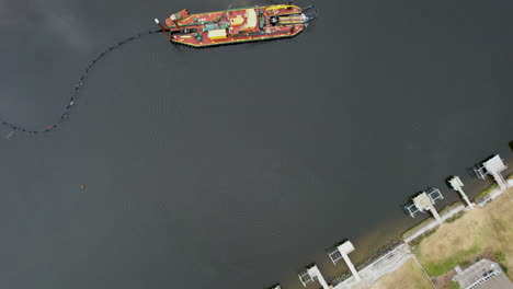 Drone-shot-of-dredging-happening-in-the-intercostal-waterway,-downward-angle-aerial-shot