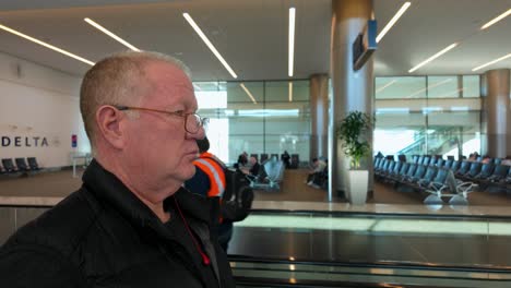 Moving-walkway-at-the-Salt-Lake-City-International-airport---senior-man-traveling-alone