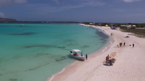 Los-roques-archipelago-with-crystal-clear-waters,-white-sandy-beach,-and-scattered-tourists-enjoying-the-tropical-sun,-aerial-view