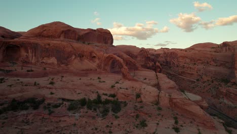 Drone-shot-flying-towards-the-Corona-Arch-in-Moab,-Utah-at-golden-hour