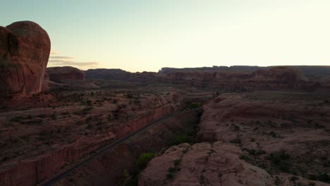 Drone-shot-flying-in-a-canyon-with-train-tracks-in-Moab,-Utah
