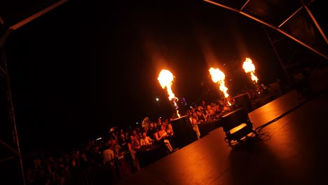 Festival-fire-show-live-on-stage-with-crowd-excited,-view-from-backstage