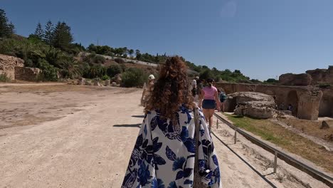 Follow-shot,-Girl-walking-in-Pareo-in-Carthage,-Tunisia