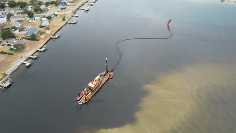 Drone-shot-of-dredging-happening-in-the-intercostal-waterway,-wide-slowly-moving-aerial-shot