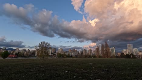 Zeitraffervideo-Von-Sich-Bewegenden-Wolken-Bei-Sonnenuntergang-In-Einem-Park-Mit-Menschen,-Die-Auf-Einem-Weg-Gehen