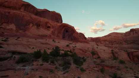Low-drone-shot-flying-towards-the-Corona-Arch-in-Moab,-UT-at-sunset-golden-hour