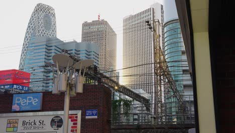 Toma-De-Fondo-Estática-De-La-Ciudad-De-Tokio-En-Un-Día-Cálido-Mientras-Pasa-El-Tren.