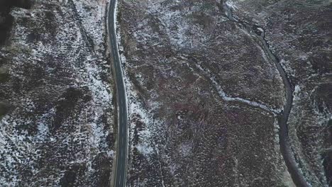 Winding-road-through-snowy-landscape,-Isle-of-Skye,-Scotland,-serene-and-isolated,-top-down-aerial-view