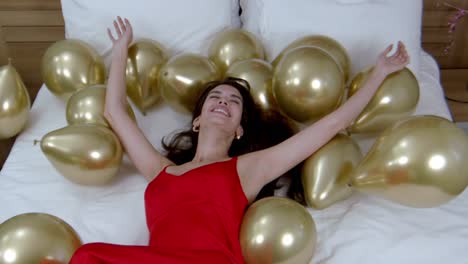 Beautiful-model-gracefully-descends-onto-collection-of-balloons