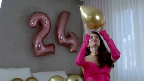 A-beautiful-Brazilian-female-fashion-model-with-a-big-smile-throws-gold-balloons-into-the-air
