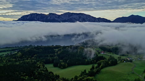 Aerial-approaching-view-of-fog-moving-between-the-Austrian-alps-before-sunrise