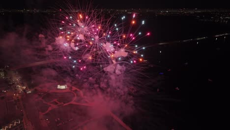 Aerial-orbit-around-New-Year's-Eve-firework-in-Fort-Myers,-Florida,-city-lights